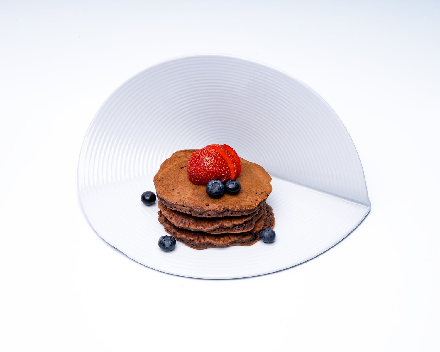 Cacao Protein Pancakes — Cacao oat pancakes, strawberries and blueberries.